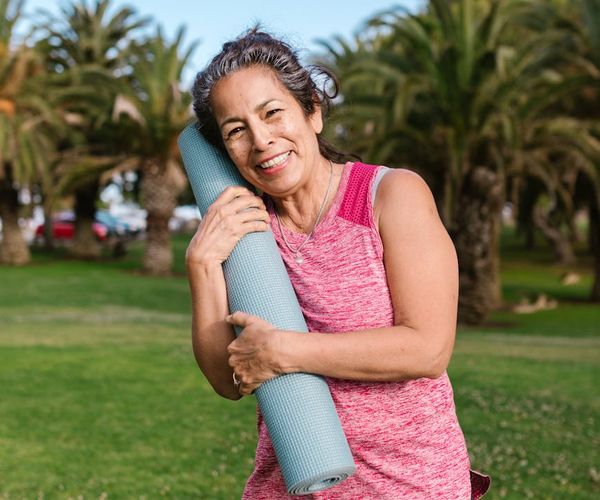 Person smiling peacefully outdoors, representing well-being.